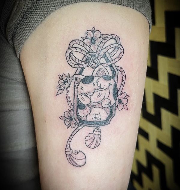 Japanese charm tattoo by LoLo, on the thigh